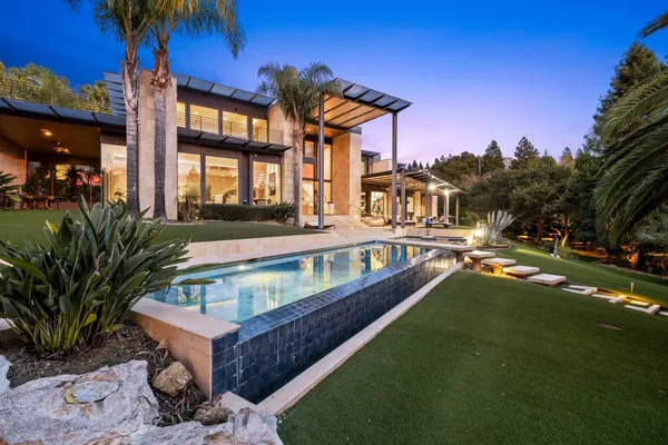 a view of a house with a swimming pool and a chairs