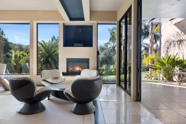 a living room with furniture fireplace and large windows