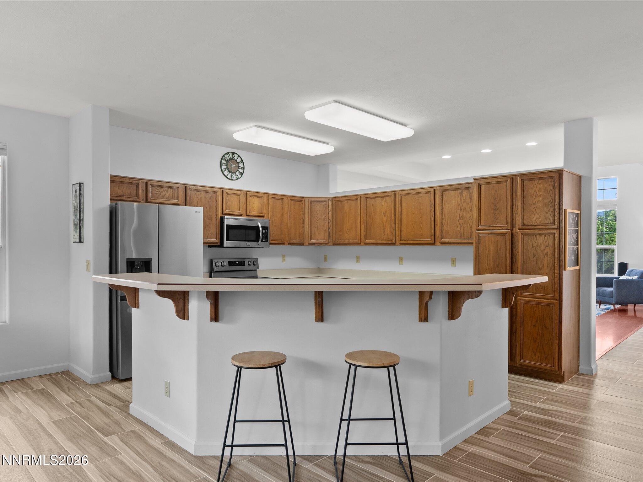 3101 Green River Drive Reno, NV 89503 - Photo 11 of 62 a kitchen with stainless steel appliances a white refrigerator oven a sink dishwasher and white cabinets with wooden floor