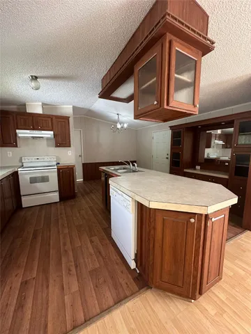 a kitchen with kitchen island wooden floors and stainless steel appliances