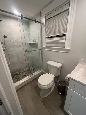 a bathroom with a toilet and a shower