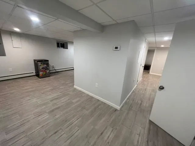 an empty room with wooden floor and mirror