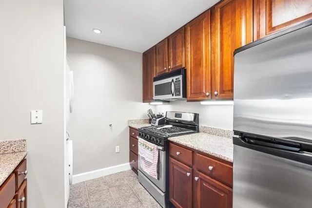 a kitchen with stainless steel appliances granite countertop a stove a sink and a microwave