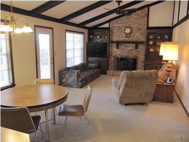 4265 April Road Pensacola, FL 32504 - Photo 8 of 25 View of the family room from the kitchen. The vaulted ceiling with exposed beams peaks at over 12'. The fireplace is wood burning.