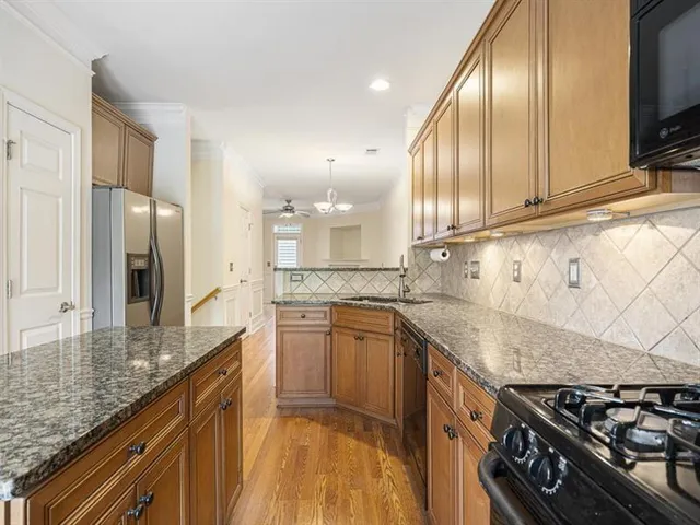 a view of a kitchen with kitchen island a stove windows and wooden floor