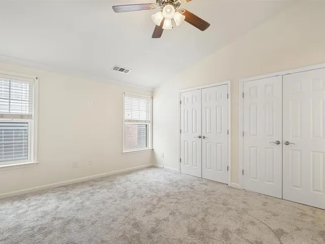 an empty room with chandelier fan