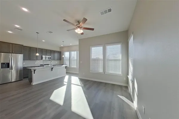 a large white kitchen with a large window appliances and cabinets