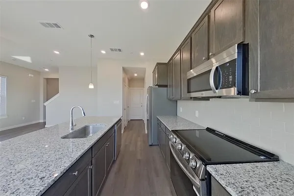 a kitchen with stainless steel appliances granite countertop a sink and a microwave