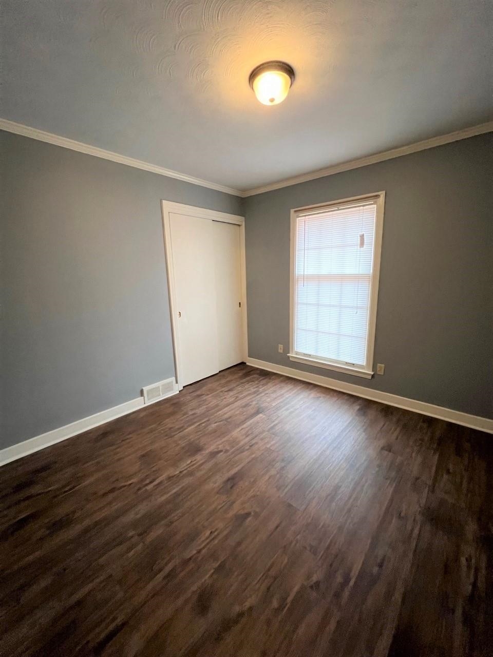 448 North White Station Road Memphis, TN 38120 - Photo 5 of 9 an empty room with wooden floor and windows