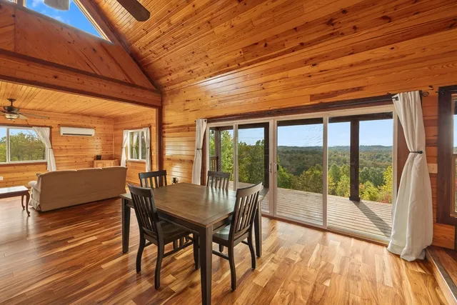 a dining room with furniture large windows and wooden floor