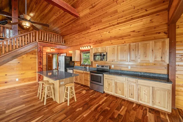 a kitchen with stainless steel appliances granite countertop a stove and cabinets with wooden floor