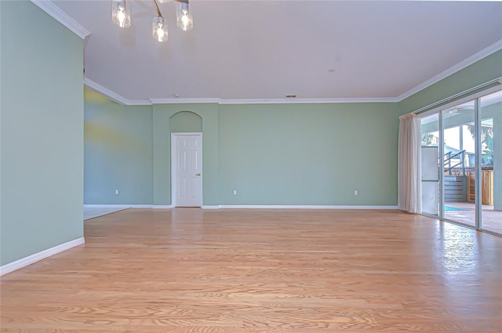 22704 Cliffside Way Land O' Lakes, FL 34639 - Photo 9 of 33 a view of an empty room with wooden floor and a window