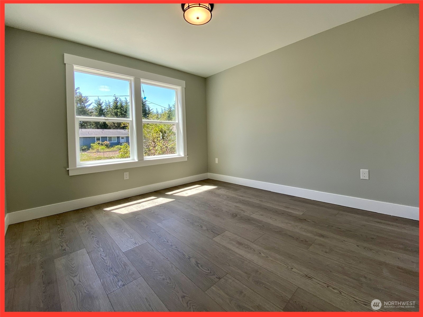 154 Seagate Street Southwest Ocean Shores, WA 98569 - Photo 26 of 36 a view of an empty room with wooden floor and a window