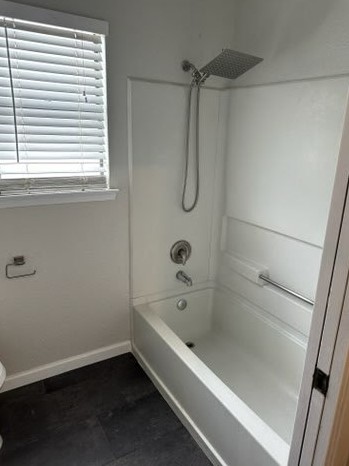 4520 Speedway, Unit A Austin, TX 78751 - Photo 9 of 18 Dark tile flooring contrasts with clean white finishes in this modern bathroom setup.