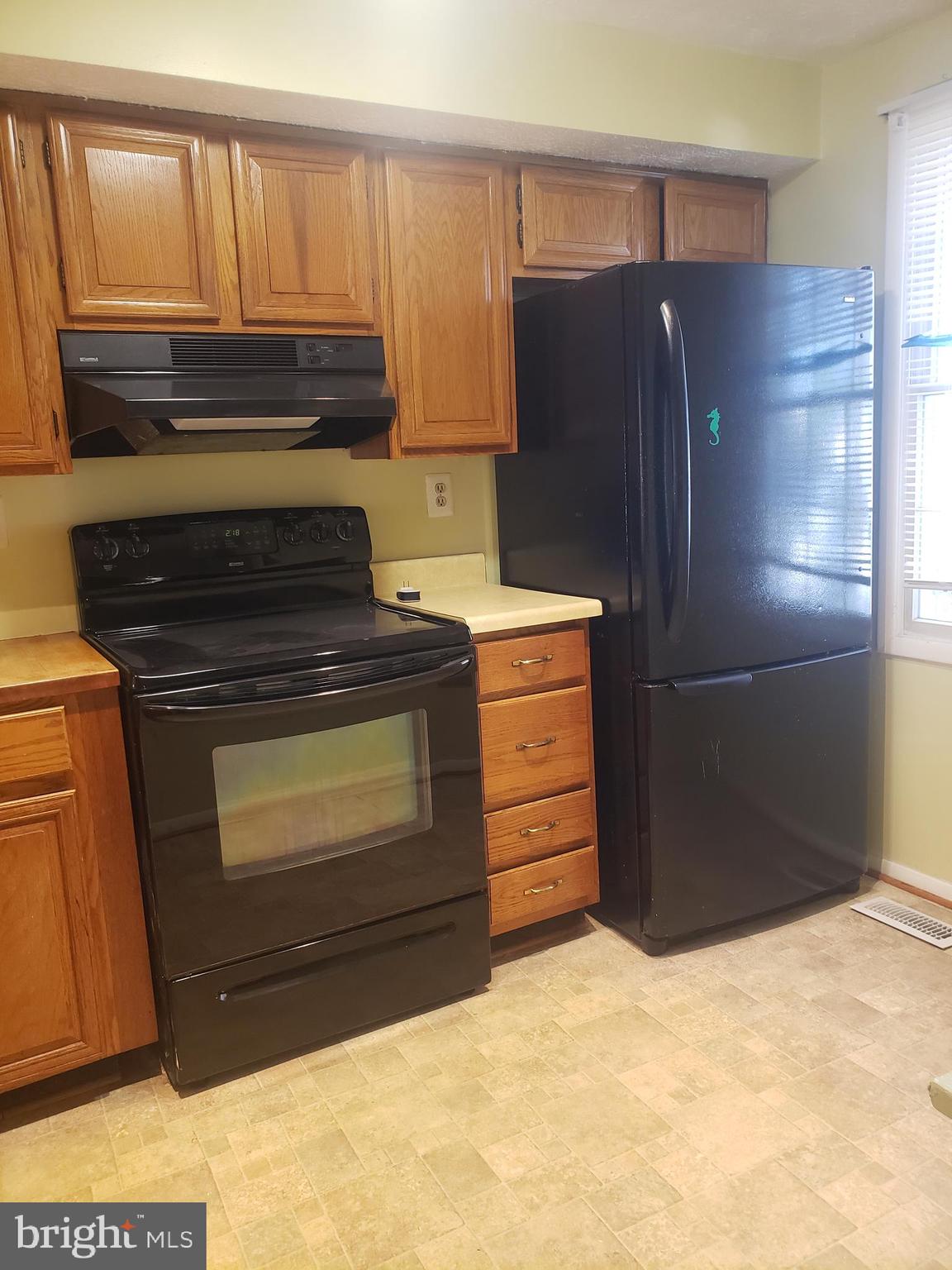 14582 Farmcrest Place Silver Spring, MD 20905 - Photo 5 of 19 a kitchen with granite countertop a refrigerator and a stove