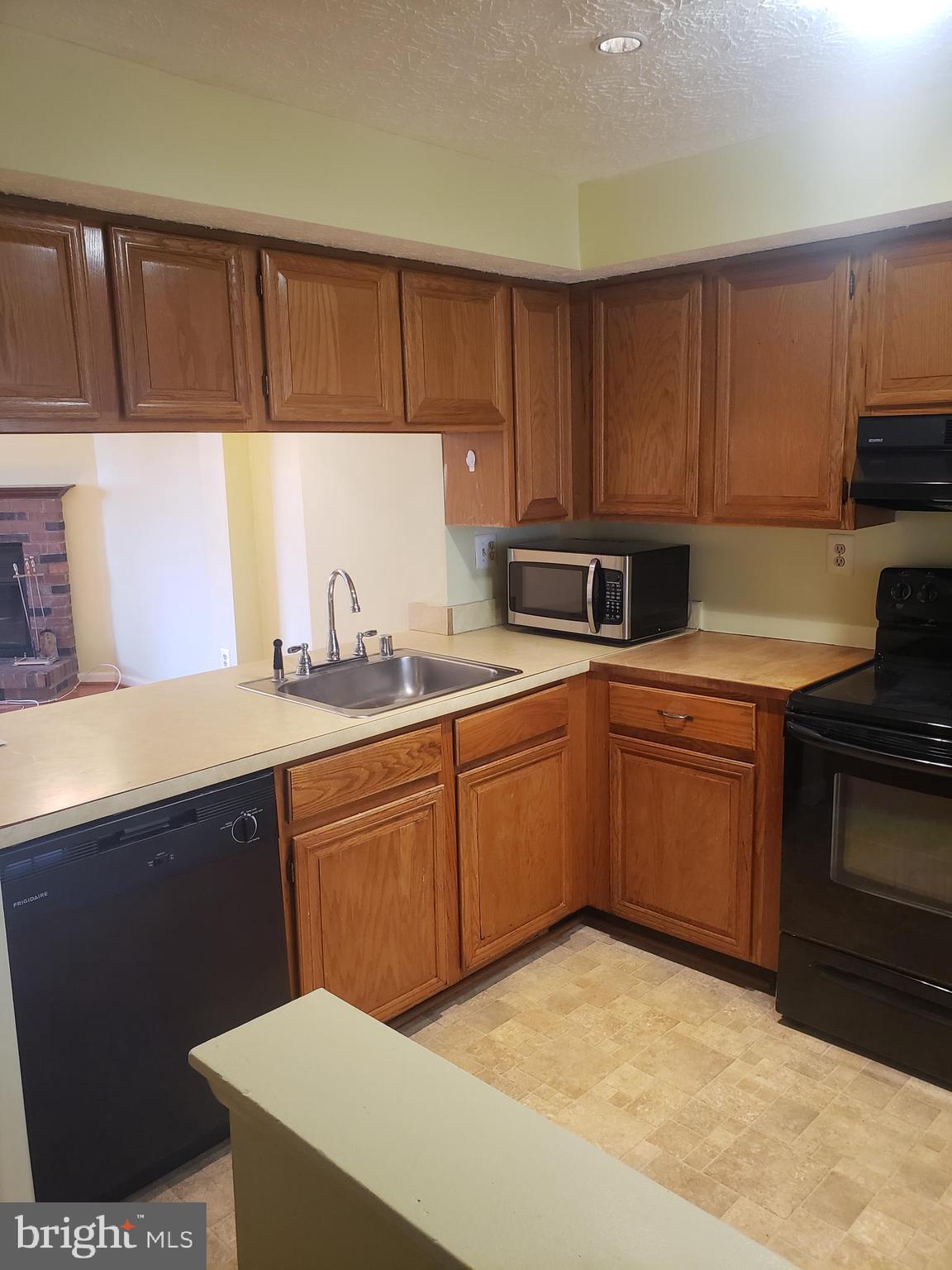 14582 Farmcrest Place Silver Spring, MD 20905 - Photo 6 of 19 a kitchen with a sink cabinets and a stove top oven