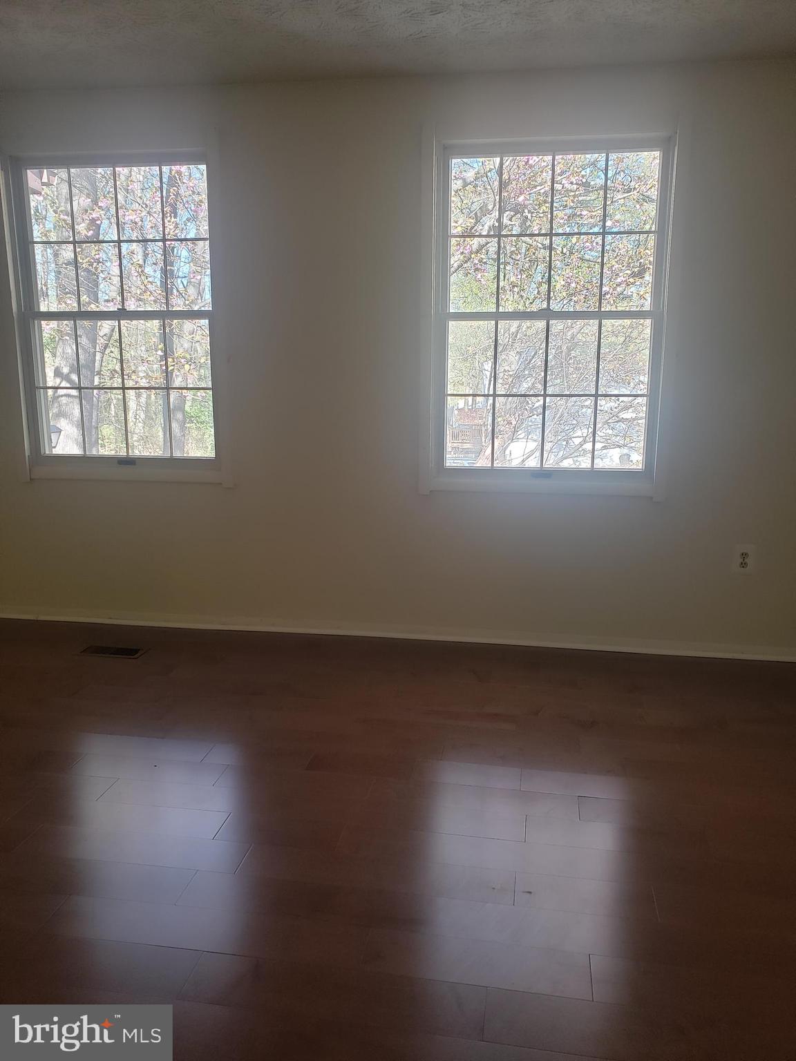 14582 Farmcrest Place Silver Spring, MD 20905 - Photo 9 of 19 an empty room with wooden floor and windows