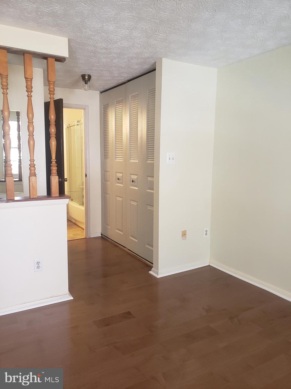 14582 Farmcrest Place Silver Spring, MD 20905 - Photo 10 of 19 an empty room with windows and entrance to kitchen