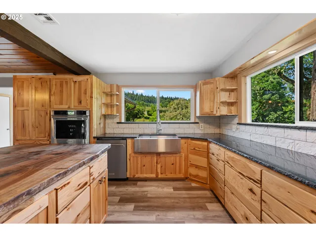 a kitchen with stainless steel appliances granite countertop a sink and a stove