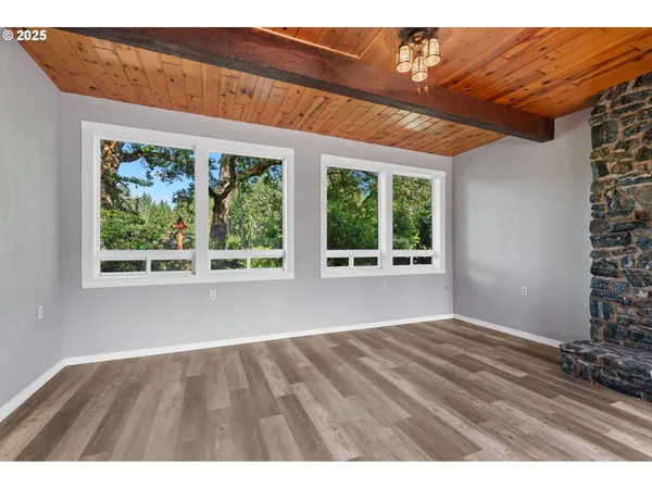 a view of an empty room with a fireplace and a window
