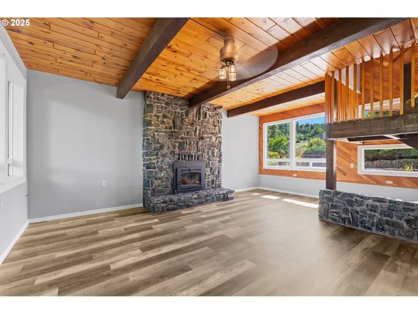 a view of empty room with fireplace and windows