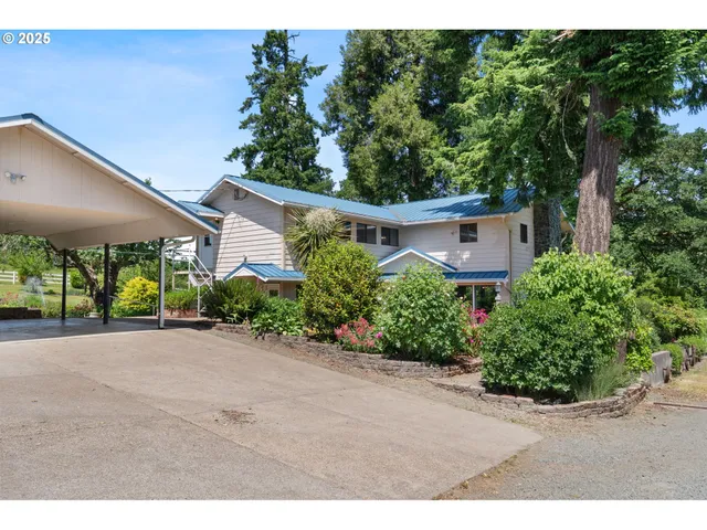 a front view of a house with a yard and potted plants