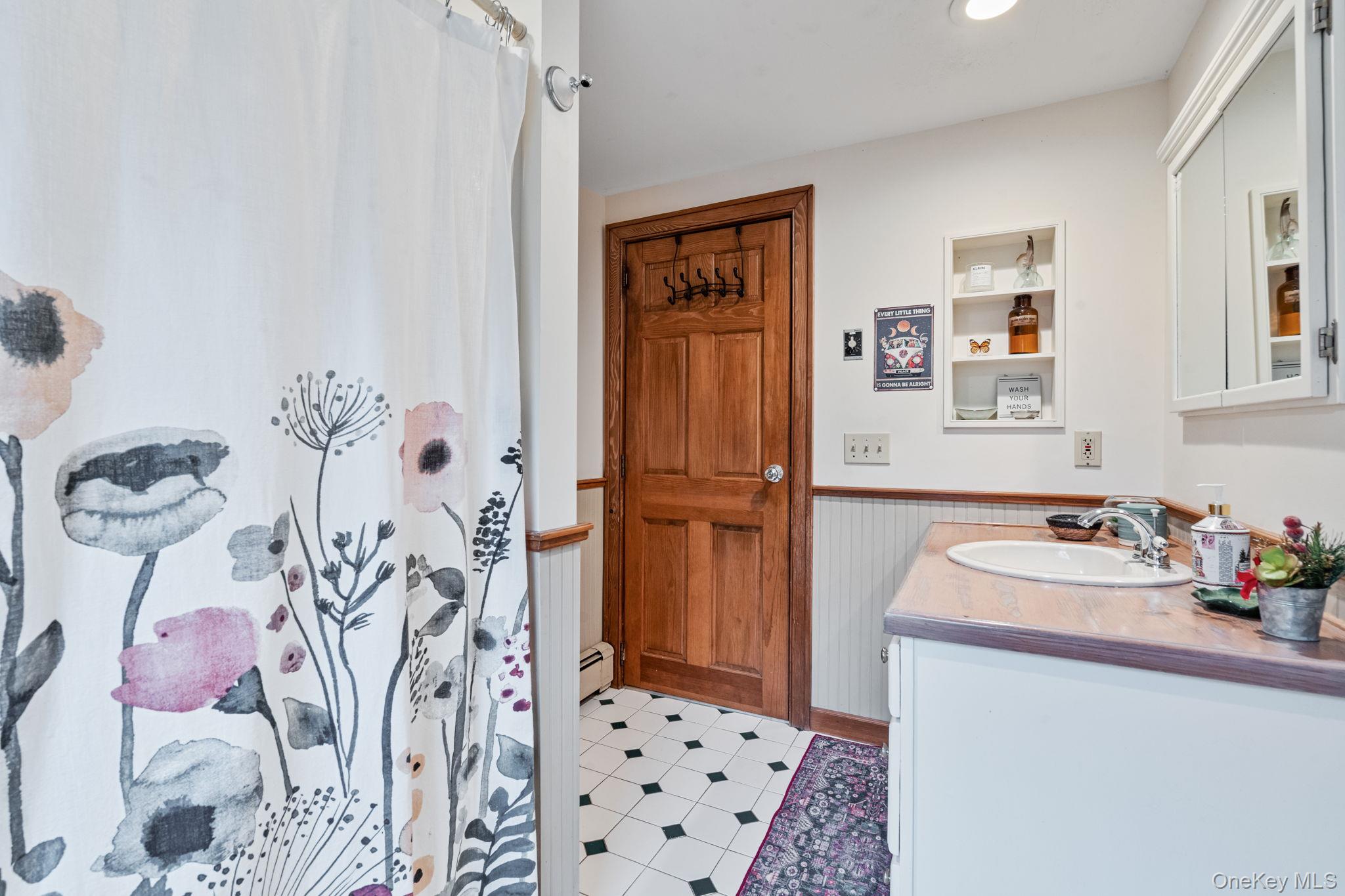170 North Country Road Miller Place, NY 11764 - Photo 27 of 48 a bathroom with a sink and a shower curtain