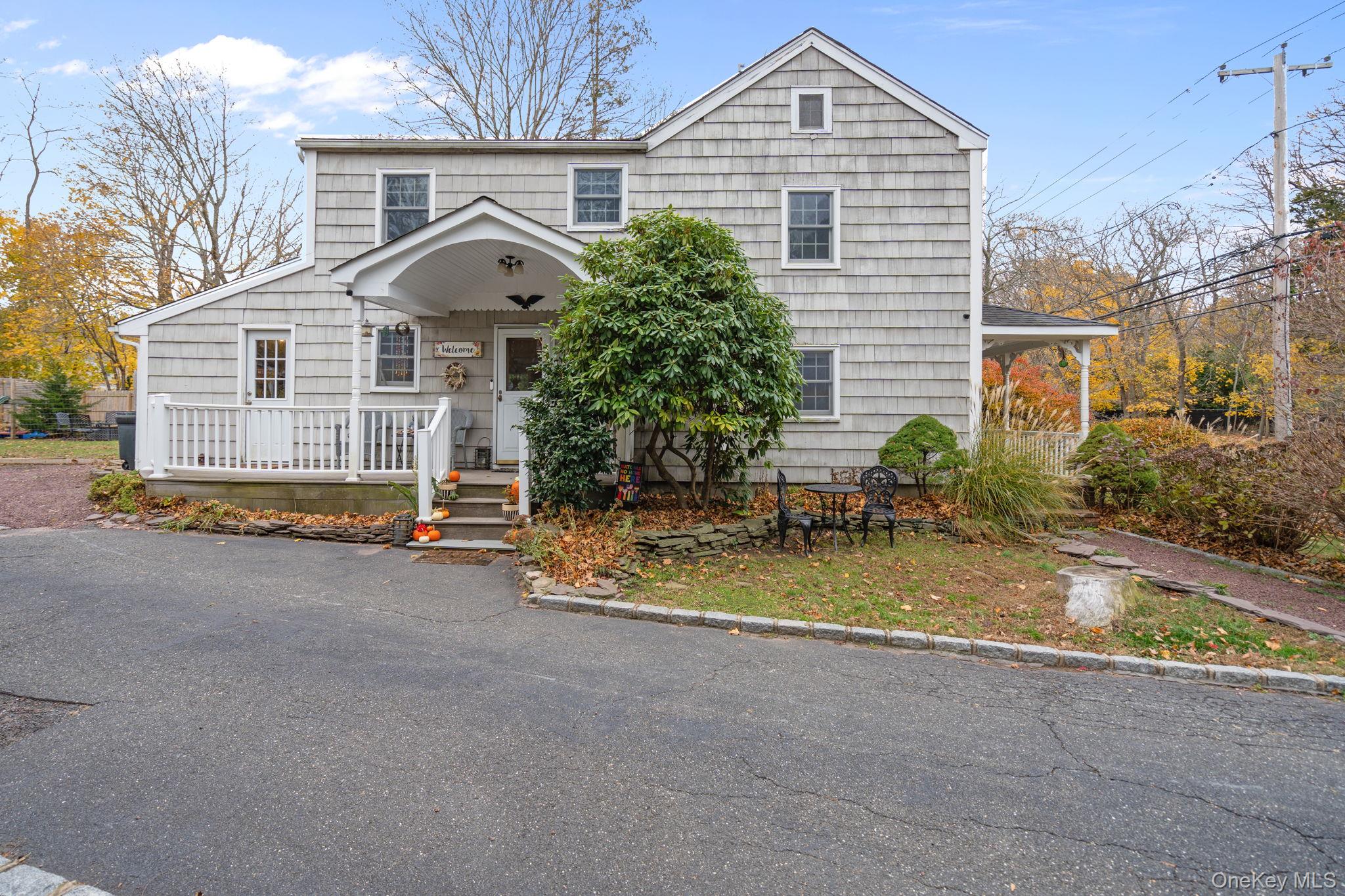 170 North Country Road Miller Place, NY 11764 - Photo 5 of 48 a front view of a house with a yard and garage