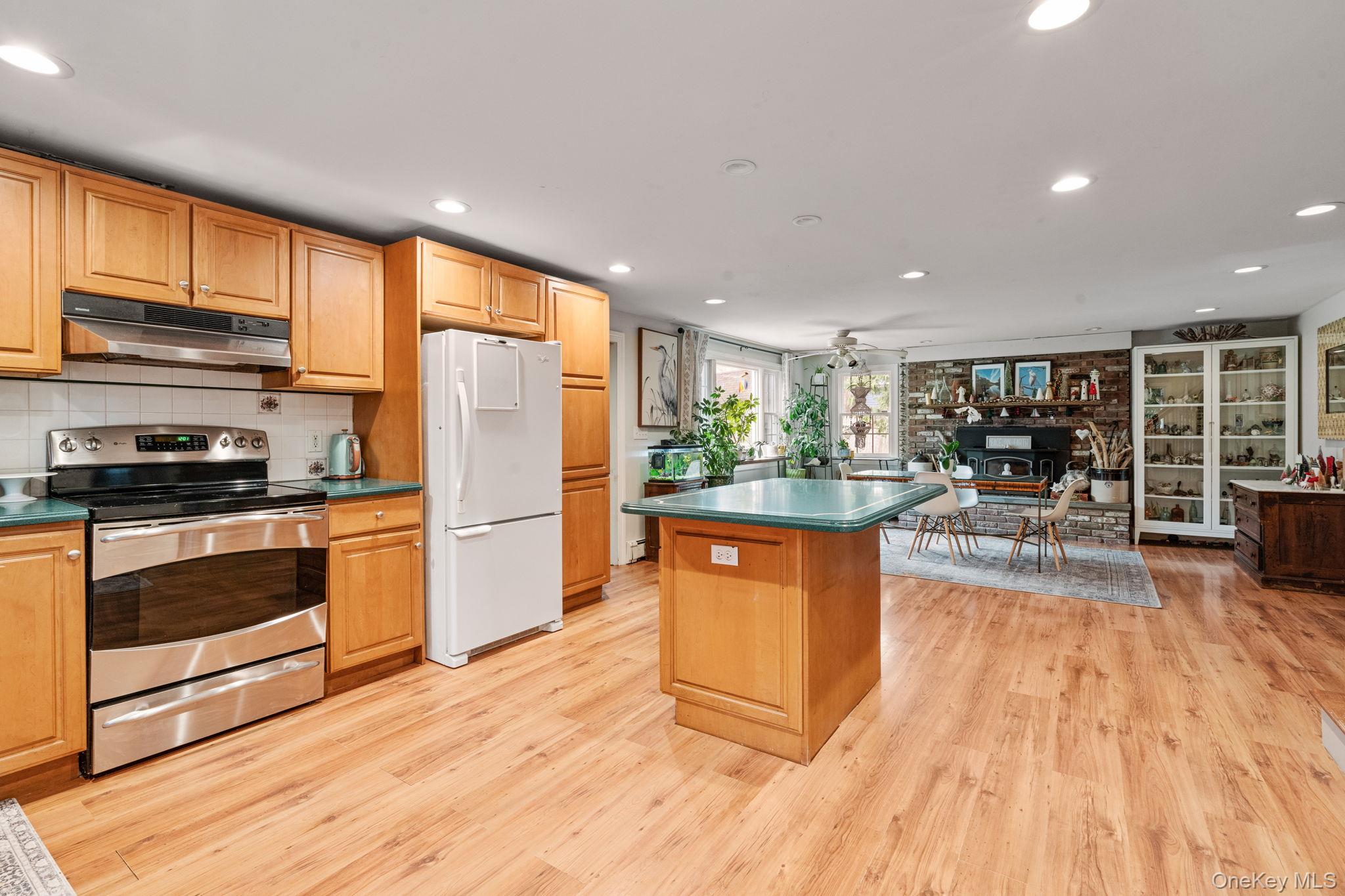 170 North Country Road Miller Place, NY 11764 - Photo 6 of 48 a kitchen with stainless steel appliances granite countertop wooden cabinets a sink a stove a dining table and chairs