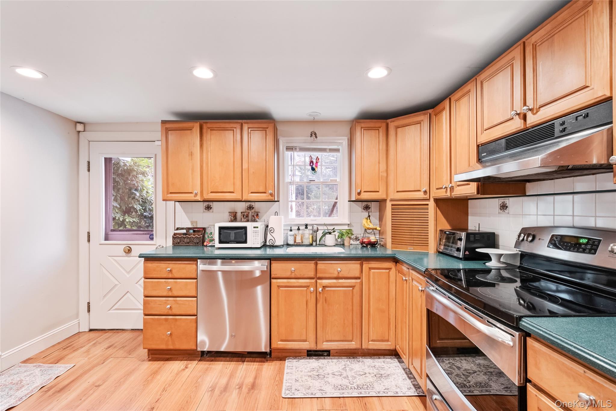 170 North Country Road Miller Place, NY 11764 - Photo 7 of 48 a kitchen with stainless steel appliances granite countertop a stove a sink and a microwave