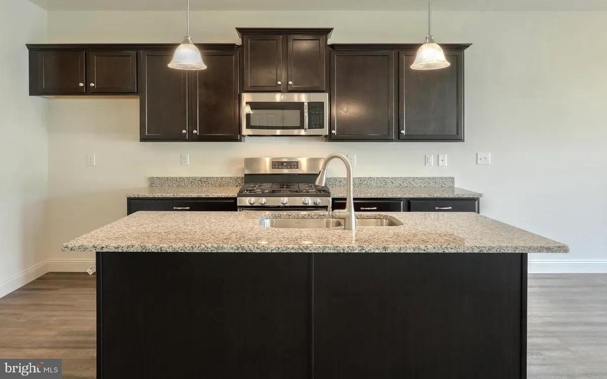 4118 Orrs Bridge Road, Unit 27 Mechanicsburg, PA 17050 - Photo 2 of 18 a kitchen with granite countertop a sink a stove a microwave and wooden cabinets