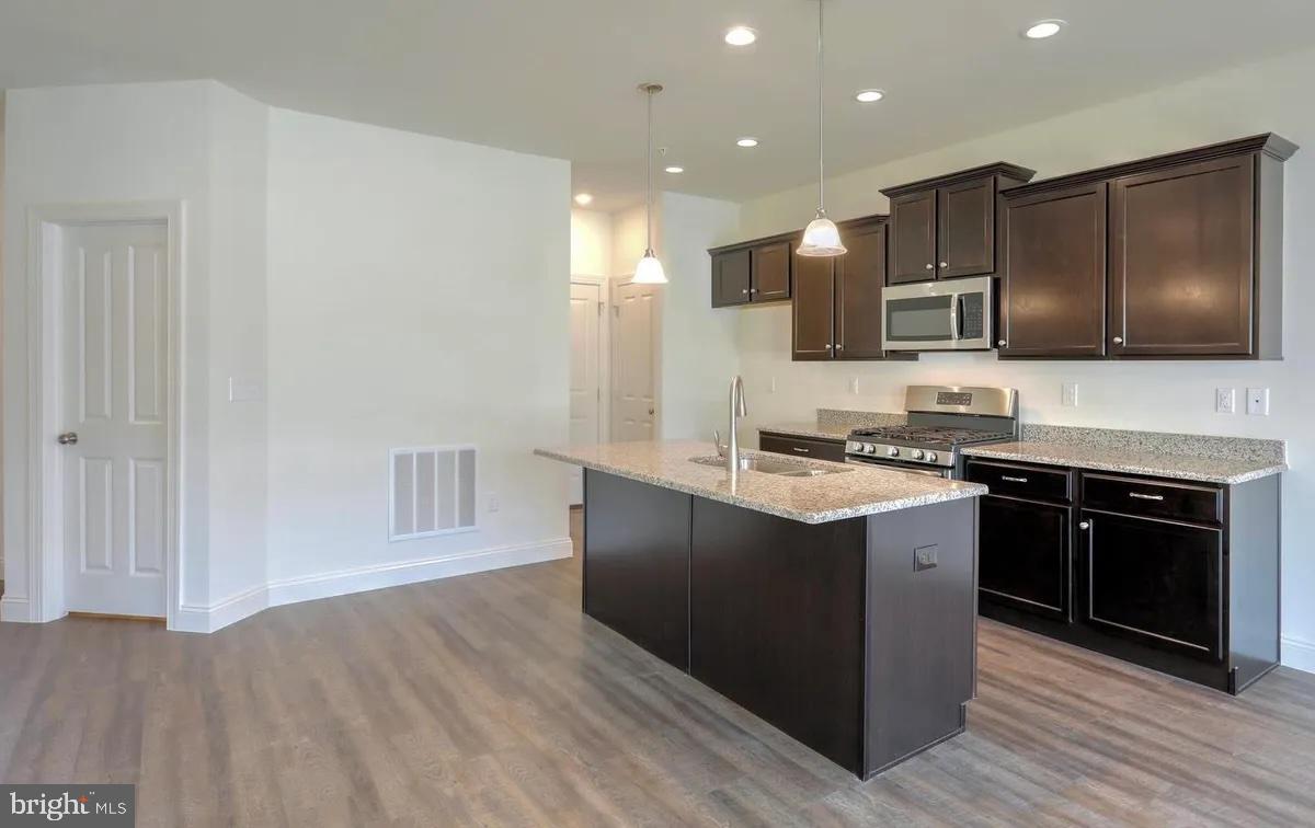 4118 Orrs Bridge Road, Unit 27 Mechanicsburg, PA 17050 - Photo 5 of 18 a kitchen with stainless steel appliances kitchen island granite countertop a stove a sink and a microwave