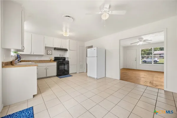 a kitchen with white cabinets and white appliances