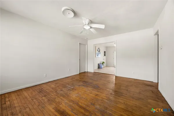 a view of empty room with wooden floor