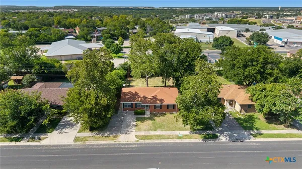 an aerial view of a house with a yard and lake view