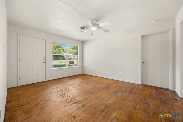 wooden floor in an empty room with a window