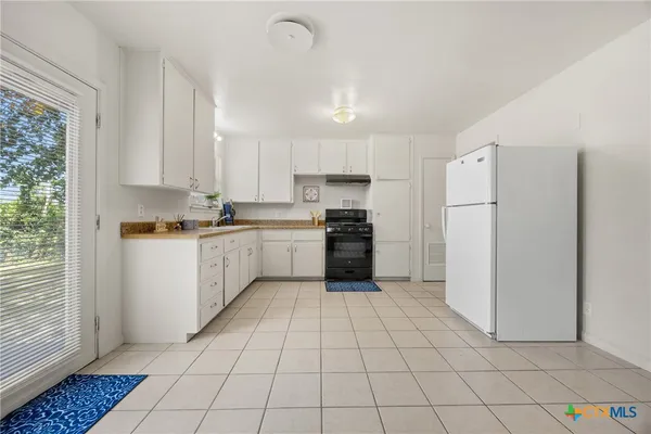 a kitchen with a cabinets a sink a window and stainless steel appliances