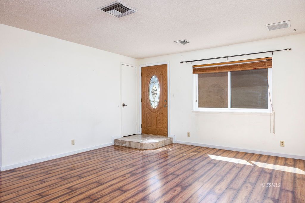 1144 West Benson Avenue Ridgecrest, CA 93555 - Photo 7 of 32 a view of empty room with wooden floor and fan