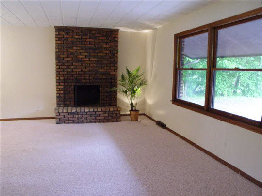 3005 Spring Creek Road Rockford, IL 61107 - Photo 2 of 6 a view of an empty room with a fireplace and a window