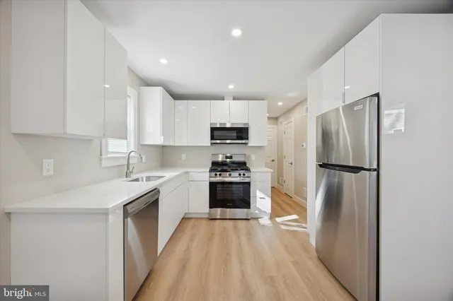 a kitchen with a refrigerator a sink and a stove top oven