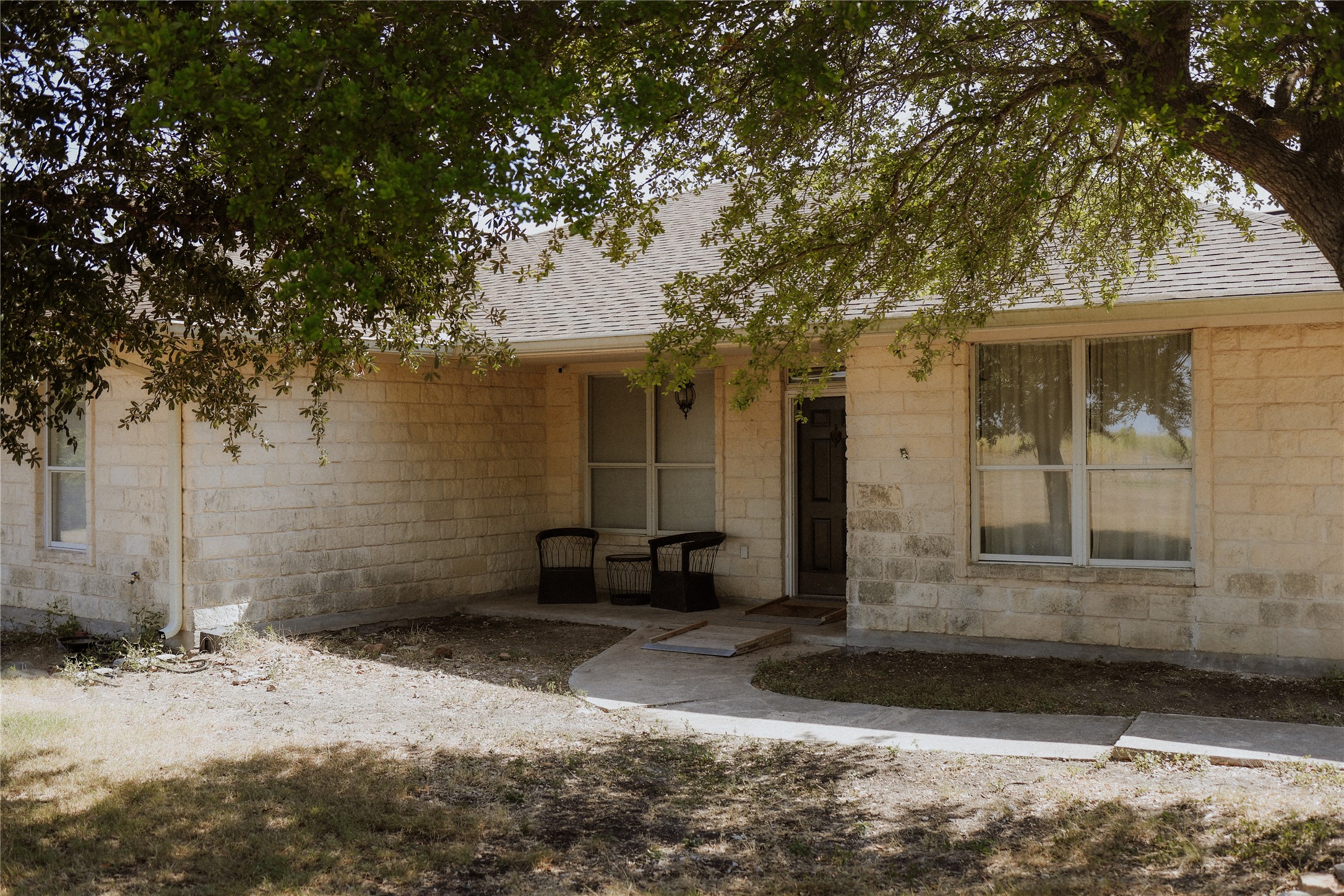 17323 Manda Carlson Road Manor, TX 78653 - Photo 4 of 29 Mature trees shade the stone exterior and inviting front entry porch of this classic home.