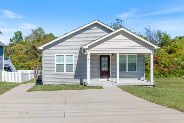 a front view of a house with a yard and potted plants