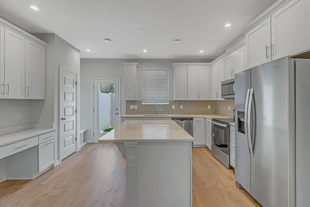 a kitchen with stainless steel appliances granite countertop a refrigerator a sink and a stove