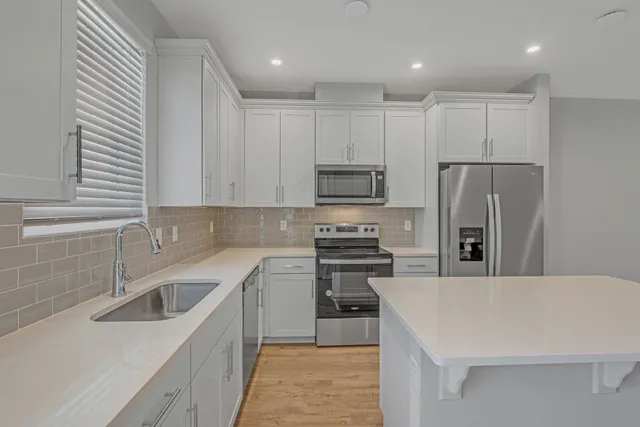 a kitchen with a sink a stove a refrigerator and cabinets