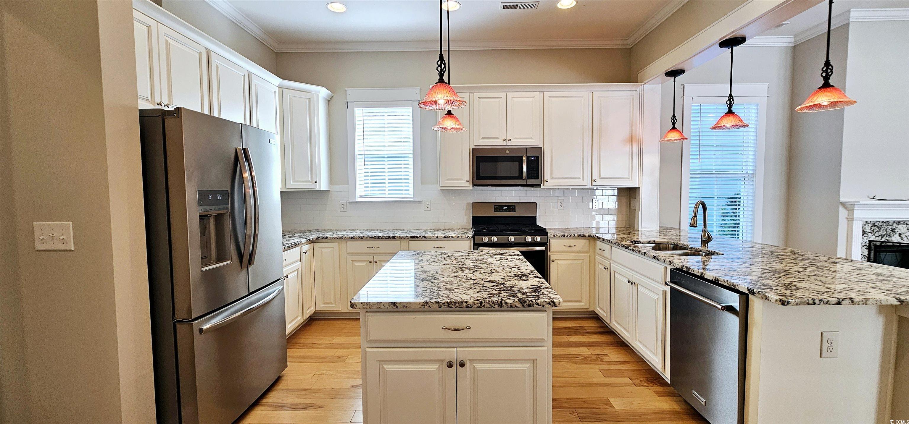 7710 Monarch Drive Myrtle Beach, SC 29572 - Photo 21 of 40 Kitchen featuring a center island, a sink, light w
