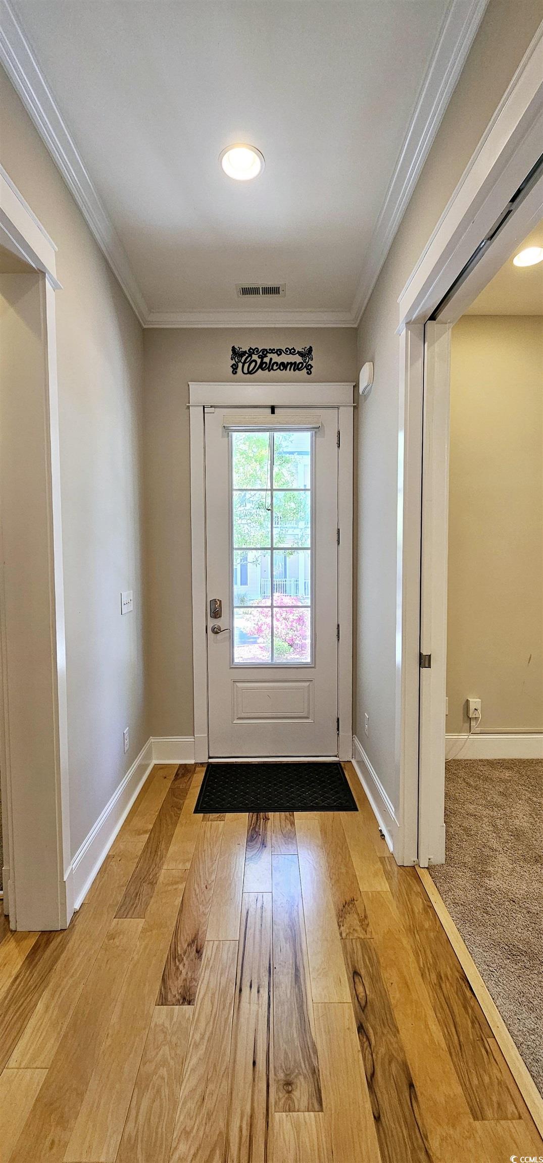 7710 Monarch Drive Myrtle Beach, SC 29572 - Photo 8 of 40 Doorway with baseboards, crown molding, light wood