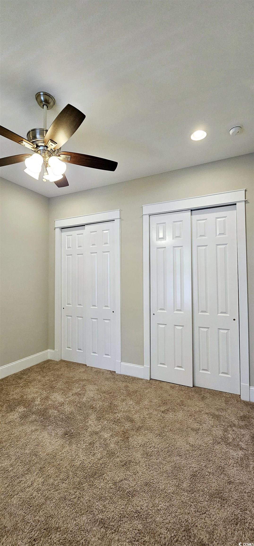 7710 Monarch Drive Myrtle Beach, SC 29572 - Photo 10 of 40 Unfurnished bedroom featuring two closets, a ceili