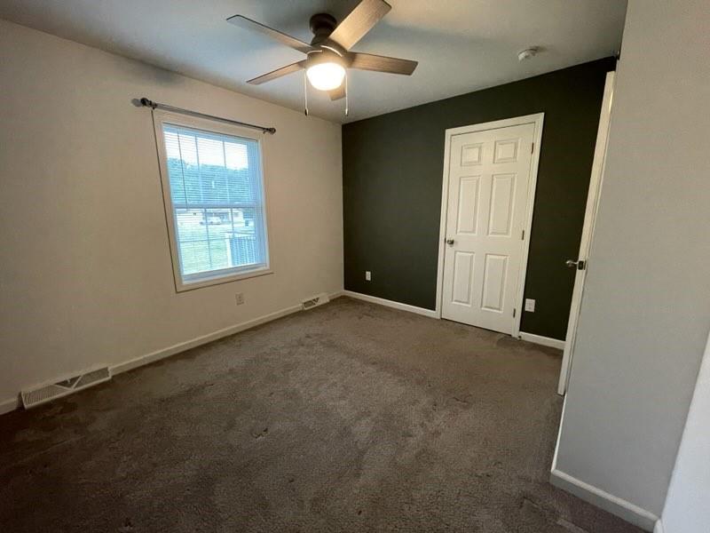 887 Mud Pike Road Smithfield, PA 15478 - Photo 32 of 36 an empty room with windows and fan