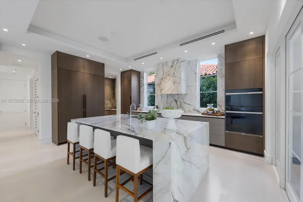 a kitchen with stainless steel appliances kitchen island granite countertop a refrigerator and a stove top oven