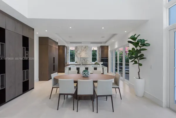 a dining room with furniture potted plants and wooden floor